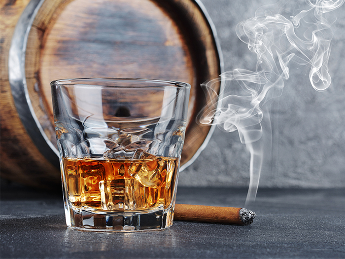 Dram of whisky with lit cigar