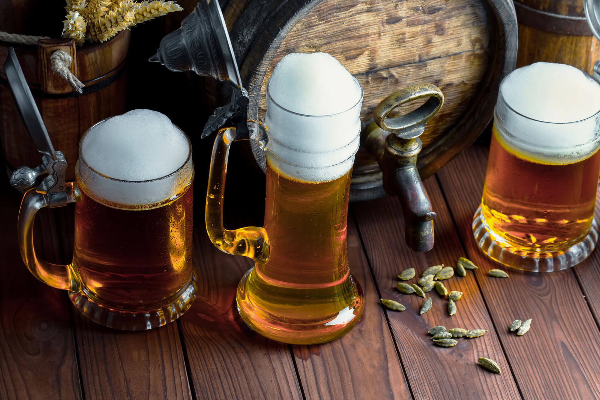 Light beer in a glass on the table in front of an old wooden keg